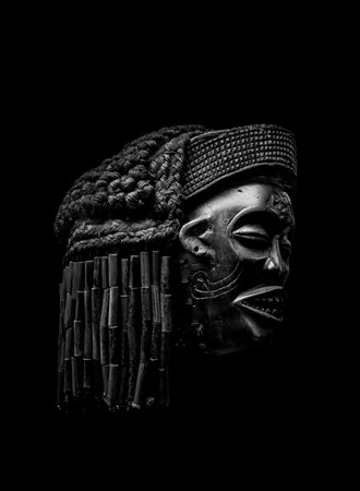 Arfican head sculpture isolated on black background photo
