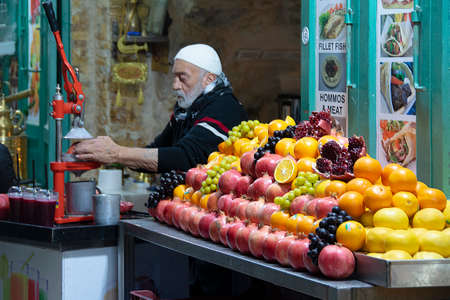 JERUSALEM, ISRAEL, DECEMBER - 2019 - Senior man preparing juice at street market, old city of...