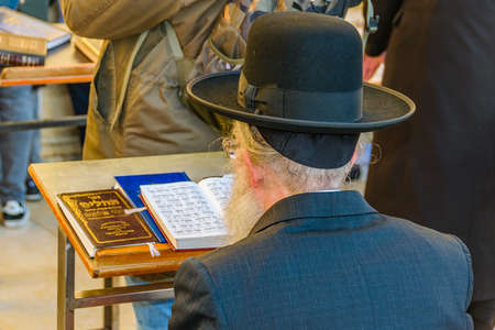 Senior man reading at wailing wall, old jerusalem cityの写真素材