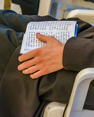 Detail view of man reading tora book at famous wailing wall, old jerusalem cityの写真素材