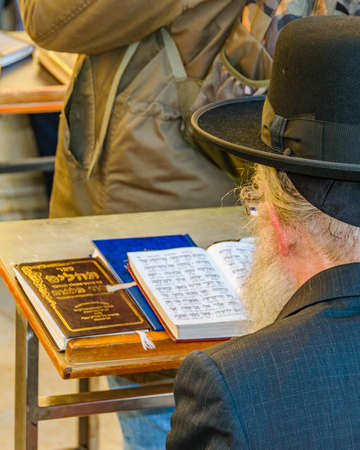 Senior man reading at wailing wall, old jerusalem cityのeditorial素材