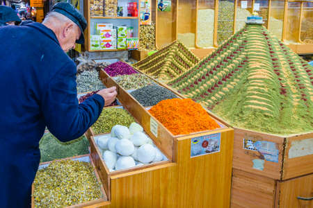 JERUSALEM, ISRAEL, DECEMBER - 2019 - Senior man picking out spices at street market, old city of...