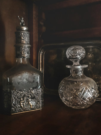 Two ornated alcoholic drink bottles over wooden furnitureの写真素材