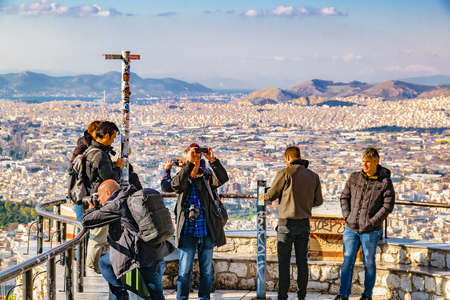 ATHENS, GREECE, JANUARY - 2020 - Tourists taking photos at lycabettus hill viewpoint, athens, greece