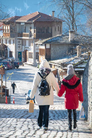 Mother and daughter walking at street, metsovo town, greeceの写真素材