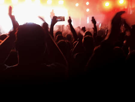 Punk rock band playing at crowded happy audience.