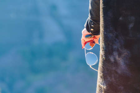 Back view zoom woman holding sunglasses detail photoの写真素材