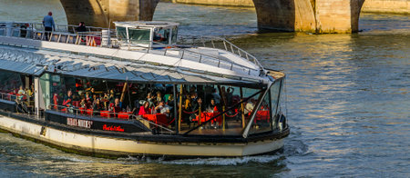 PARIS, FRANCE, JANUARY - 2020 - Crowded touristic ferry crossing seine river, paris, franceのeditorial素材