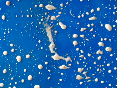 Top view detail shot ice cream drops over blue plastic