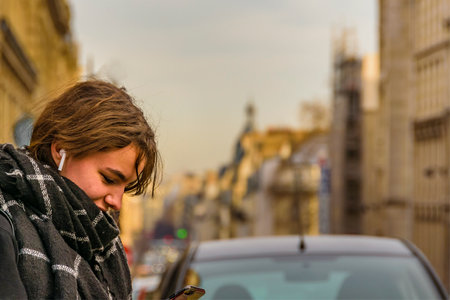 PARIS, FRANCE, JANUARY - 2020 - Middle shot urban scene young attractive woman watching his smartphone, paris, franceのeditorial素材