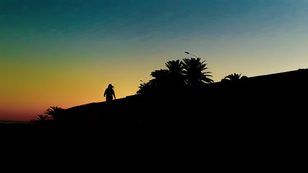 Urban sunset scene woman walking at boardwalk, montevideo, uruguayの写真素材