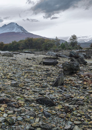 Rocky ground and snowy Andes mountain in background, Tierra del Fuego National Park, Argentinaのeditorial素材