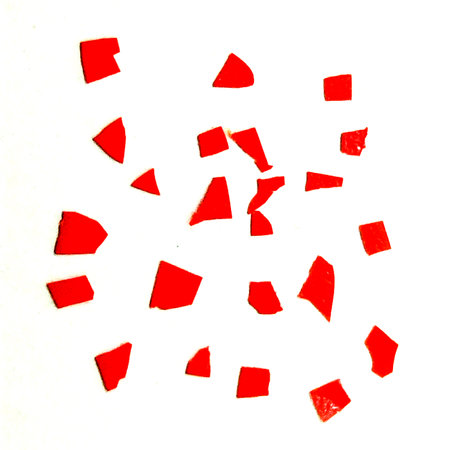 Red plastic broken pieces over white backgroundの写真素材