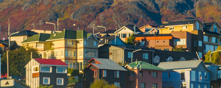 Gable roof apartment buildings over slope of mountain, Ushuaia, Tierra del Fuego, Argentinaの写真素材