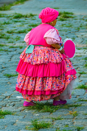 Montevideo, Uruguay; February 11 2024: Tiny old women with costume walking at street at calls parade carnival, Montevideo, Uruguay.の写真素材