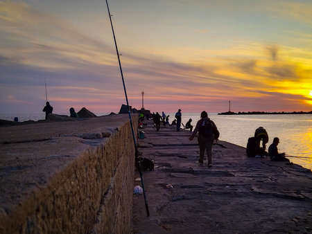 People fishing at breakwater at sunset time, Ciudad Vieja, Montevideo City, Uruguay
