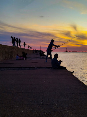 People fishing at breakwater at sunset time, Ciudad Vieja, Montevideo City, Uruguayの写真素材