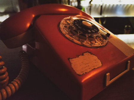 High contrast night scene vintage home telephone at table barの写真素材