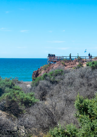 Tourists at viewpoint watching the sea landsacpe at punta tombo peninsula, chubut province, argentinaの写真素材