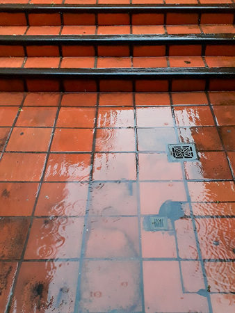 High angle shot wet square red floor pattern of residential exterior hallwayの写真素材
