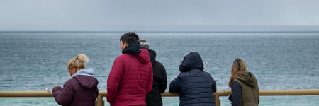 Puerto Madryn, Argentina; January 11 2023: Group of people at border of viewpoint watching sea lions...