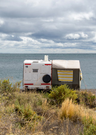 Puerto Madryn, Argentina; January 11 2023: Motorhomes and tent parked at border of cerro avanzado beach, puerto madryn city, chubut province, argentinaの写真素材