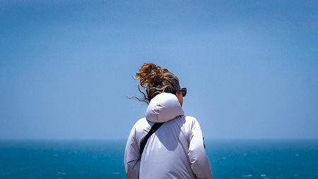 Peninsula Valdes, Argentina; December 29 2022: Young woman at viewpoint watching wildlife marine at peninsula valdes, viedma department, chubut province, argentinaの写真素材