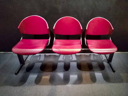 Front high angle view three red plastic seats at indoor public hall