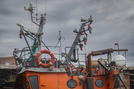 Upper deck of an old, weathered fishing boat equipped with various maritime technologies.の写真素材