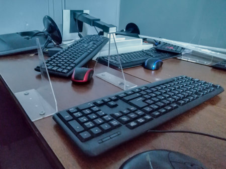 High angle shot computer equipments over wooden table at roomの写真素材