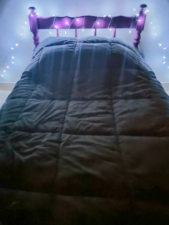 Interior night scene of kids room decorated with christmas artificial light surrounded the head of bedの写真素材
