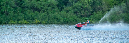 Man at jet ski sailing fast at santa lucia river, los cerrillos, canelones department, uruguayの写真素材