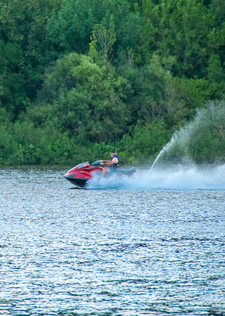 Man at jet ski sailing fast at santa lucia river, los cerrillos, canelones department, uruguay