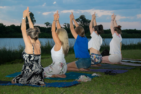 Heterogeneous women small group practicing kundalini yoga at border of river, santa lucia river, los cerrillos, canelones department, uruguayの写真素材