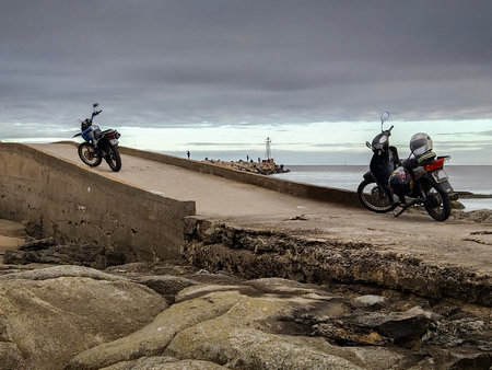 Motorcycles parked at concrete breakwater at isla del mono island, buceo bay, montevideo city, uruguayの写真素材