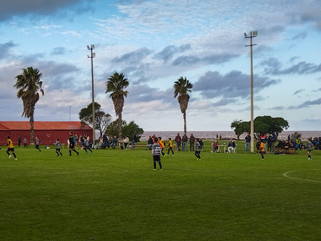 Montevideo, Uruguay; May 11 2024 - A dynamic scene of children playing soccer on an open field in punta carretas neighborhood, montevideo city, uruguay.の写真素材