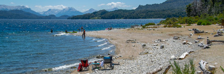 People at sunny summer day at one of the beaches of bariloche, nahuel huapi national park, rio negro province, argentina.の写真素材