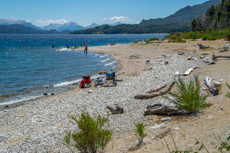 People at sunny summer day at one of the beaches of bariloche, nahuel huapi national park, rio negro province, argentina.の写真素材