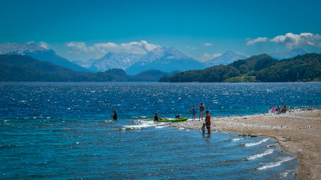 People at sunny summer day at one of the beaches of bariloche, nahuel huapi national park, rio negro province, argentina.の写真素材
