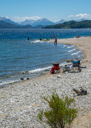 People at sunny summer day at one of the beaches of bariloche, nahuel huapi national park, rio negro province, argentina.の写真素材