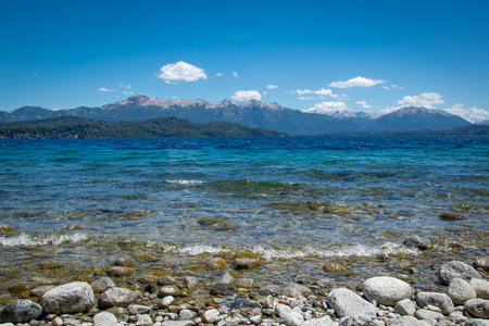 Rocky shore and andes range mountains at background at one of the beaches of bariloche, nahuel huapi national park, rio negro province, argentina.の写真素材