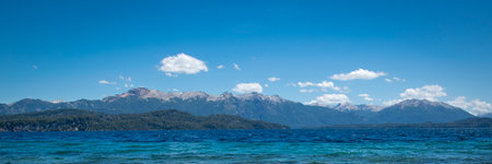 Rocky shore and andes range mountains at background at one of the beaches of bariloche, nahuel huapi national park, rio negro province, argentina.の写真素材