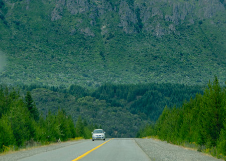 Modern highway crossing patagonian forest landscape with big andes mountain at background, rio negro province, patagonia, argentinaの写真素材