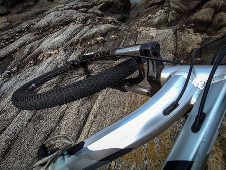 High angle view mountain bike lying on the rocks at rocky small islet called "isla del mono" located in buceo neighborhood, montevideo city, uruguayの写真素材