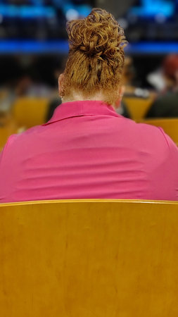 Back view shot curvy redhair woman sitting at auditorium building, montevideo city, uruguayの写真素材