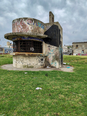 Montevideo, Uruguay: February 16 2025: An abandoned police booth stands alone in an overgrown grassy area, surrounded by residential houses in the historic district of Montevideo, Uruguay.の写真素材