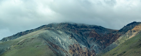 Rocky mountain covered by big white clouds at top, cushamen department, chubut province, argentinaの写真素材
