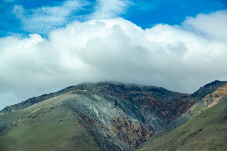 Rocky mountain covered by big white clouds at top, cushamen department, chubut province, argentinaの写真素材