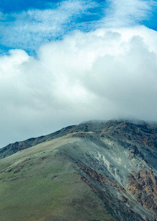 Rocky mountain covered by big white clouds at top, cushamen department, chubut province, argentinaの写真素材