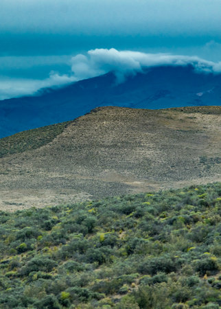 Andes mountains covered by big white clouds at top, cushamen department, chubut province, argentinaの写真素材